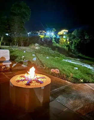 a fire pit in a yard at night at Apartment with a hot tub and a view of Guatapé lake in Guatapé