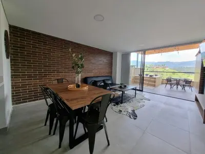 a dining room with a table and chairs and a brick wall at Apartment with a hot tub and a view of Guatapé lake in Guatapé