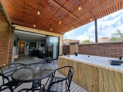 a patio with a table and chairs and a hot tub at Apartment with a hot tub and a view of Guatapé lake in Guatapé