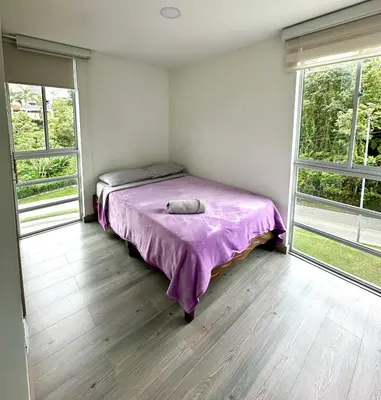 a bedroom with a bed in a room with windows at Sector Turistico, Confort y Full Amoblado in Manizales