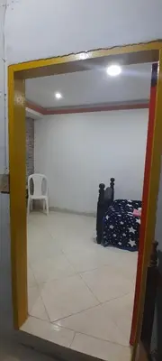 a mirror in a room with a chair and a bed at Hotel Estadero Piscina EL CACIQUE GUARKAMA in Montañadentro