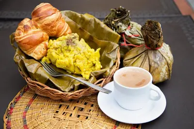 a table with a basket of bread and a cup of coffee at Hotel Estadero Piscina EL CACIQUE GUARKAMA in Montañadentro