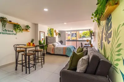 a living room with a couch and a table and a bed at Cozy Spring Flat in Laureles in Medellín