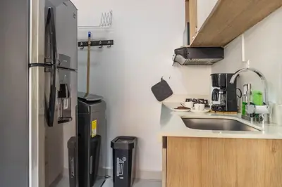 a small kitchen with a sink and a refrigerator at Cozy Spring Flat in Laureles in Medellín