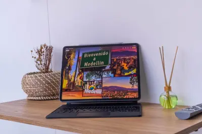 a laptop computer sitting on top of a wooden desk at Cozy Spring Flat in Laureles in Medellín