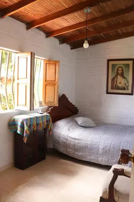 a bedroom with two beds and a painting on the wall at Casa Finca El Peñol Antioquia in El Peñol