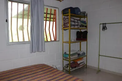 a room with a bed and a shelf with clothes at Casa Finca El Peñol Antioquia in El Peñol