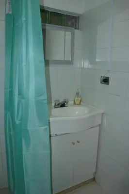 a bathroom with a sink and a blue shower curtain at Casa Finca El Peñol Antioquia in El Peñol