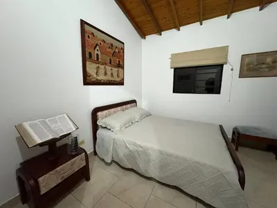 a bedroom with a bed and a laptop on a table at Casa San Antonio de Pereira in Rionegro