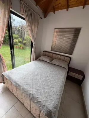 a bed in a room with a large window at Casa San Antonio de Pereira in Rionegro