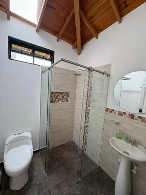 a bathroom with a toilet and a shower and a sink at Casa San Antonio de Pereira in Rionegro