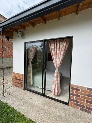 a house with glass doors with curtains on it at Casa San Antonio de Pereira in Rionegro