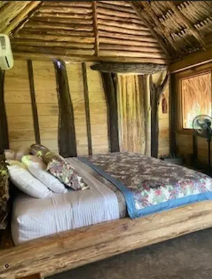 a bedroom with a bed in a log cabin at Cabaña ecologica en el Rio Cocorna, Puerto Triunfo in Providencia