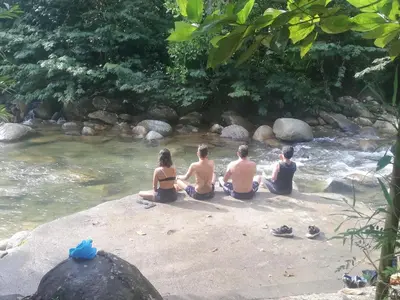 a group of people sitting on the shore of a river at Casa Arcolibri in San Rafael