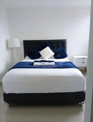 a bedroom with a large bed with blue pillows at Ap entero en Rionegro cerca Aiport JMC ,Int in Rionegro