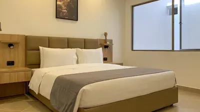 a bedroom with a large bed with a large window at Hotel Poblado Boutique in Medellín