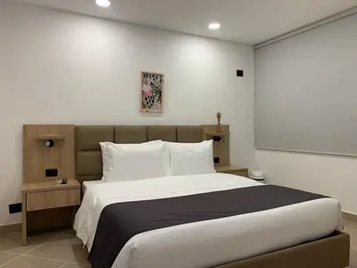 a bedroom with a large bed with white sheets at Hotel Poblado Boutique in Medellín