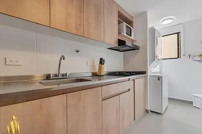 a kitchen with wooden cabinets and a stainless steel refrigerator at Ankara 301 - Contemporary Loft Trendy in provenza in El Poblado