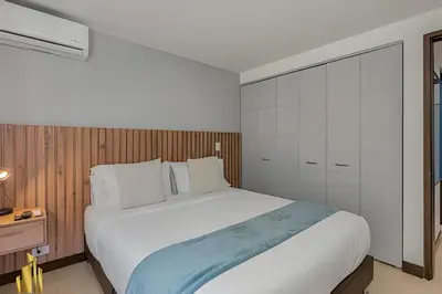 a bedroom with a large white bed and a cabinet at Ankara 401 - Modern and comfort Apt in Provenza in El Poblado