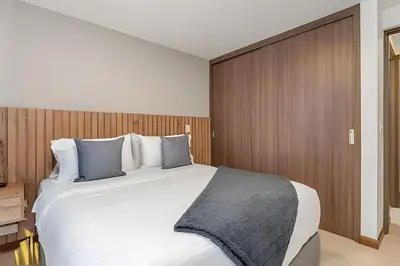 a bedroom with a large white bed with blue pillows at Ankara 501 - Modern Apt inside Provenza with AC in El Poblado