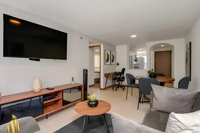 a living room with a couch and a tv on a wall at Ankara 501 - Modern Apt inside Provenza with AC in El Poblado