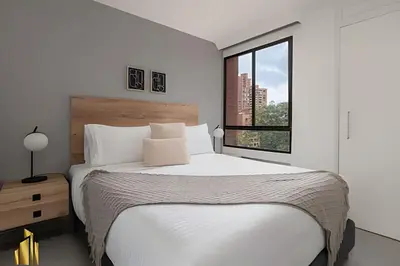a white bedroom with a large bed and a window at Ankara 701 - Contemporary clean loft/ Provenza in El Poblado