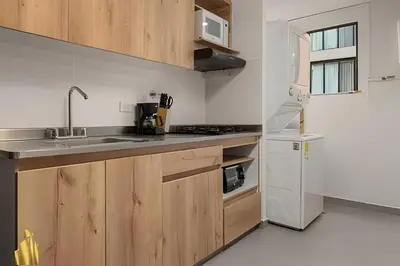 a kitchen with wooden cabinets and a sink at Ankara 701 - Contemporary clean loft/ Provenza in El Poblado