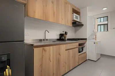 a kitchen with wooden cabinets and a sink at Ankara 701 - Contemporary clean loft/ Provenza in El Poblado