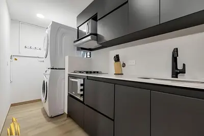 a kitchen with black cabinets and a white refrigerator at Ankara 802 - Secure & Private apt/ Trendy Provenza in El Poblado