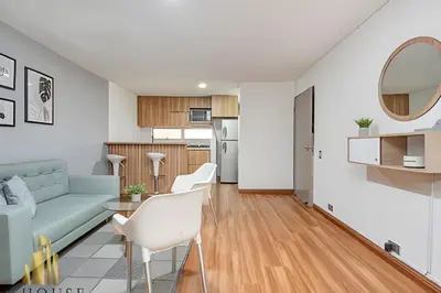 a living room and kitchen with a couch and a table at Aria Living 200 - Vibrant Apartment in Laureles in Guayaquil