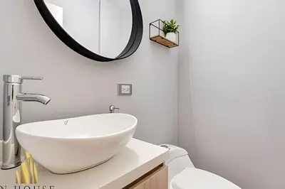a bathroom with a white sink and a mirror at Aria Living 200 - Vibrant Apartment in Laureles in Guayaquil