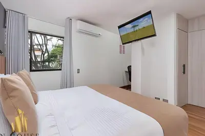 a bedroom with a bed with a flat screen tv on the wall at Aria Living 200 - Vibrant Apartment in Laureles in Guayaquil