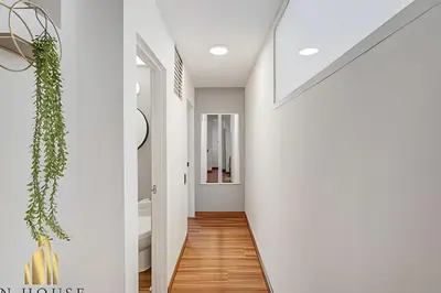 a hallway of a house with white walls and wooden floors at Aria Living 201 - Where Design and Location Shine in Guayaquil