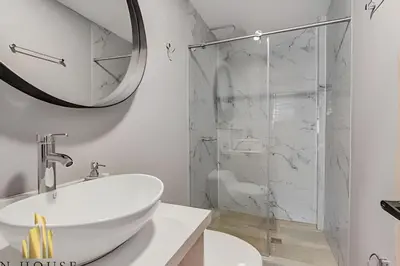 a white bathroom with a sink and a shower at Aria Living 201 - Where Design and Location Shine in Guayaquil