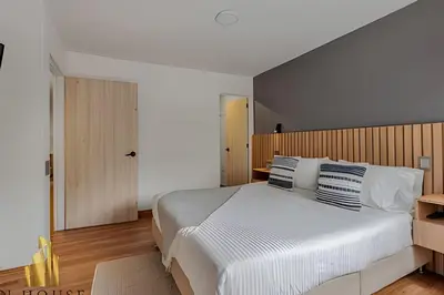 a bedroom with a large white bed with blue and white pillows at Aria Living 201 - Where Design and Location Shine in Guayaquil