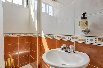 a bathroom with a white sink and a mirror at Aria Living 202 - Spacious Urban Luxury Retreat in Guayaquil