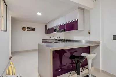 a kitchen with white cabinets and purple accents at Aria Living 202 - Spacious Urban Luxury Retreat in Guayaquil