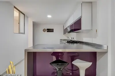 a kitchen with a purple island with a purple stool at Aria Living 202 - Spacious Urban Luxury Retreat in Guayaquil