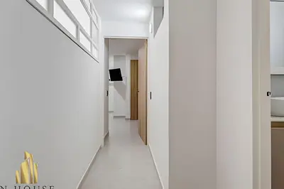 a hallway of a house with white walls and white floors at Aria Living 300 - Style and Urban Comfort in Guayaquil