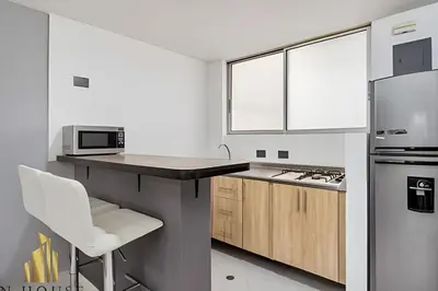 a kitchen with a counter with a microwave and a refrigerator at Aria Living 300 - Style and Urban Comfort in Guayaquil