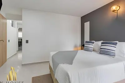 a bedroom with a white bed with blue and white pillows at Aria Living 300 - Style and Urban Comfort in Guayaquil