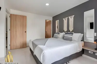a bedroom with a white bed and a gray wall at Aria Living 301 - Total Exclusivity in Laureles in Guayaquil