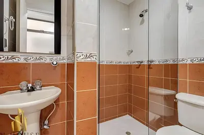 a bathroom with a sink and a toilet and a mirror at Aria Living 302 - Modern and central in Laureles in Guayaquil