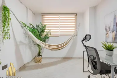 an office with a hammock in a room with plants at Aria Living 302 - Modern and central in Laureles in Guayaquil
