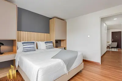 a bedroom with a large white bed with blue and white pillows at Aria Living 401 - Sophisticated Living in Laureles in Guayaquil