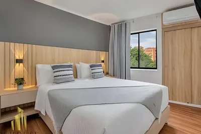 a bedroom with a large white bed and a window at Aria Living 401 - Sophisticated Living in Laureles in Guayaquil