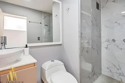 a bathroom with a toilet and a sink and a shower at Aria Living 401 - Sophisticated Living in Laureles in Guayaquil
