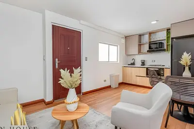 a living room with a white couch and a table at Aria Living 401 - Sophisticated Living in Laureles in Guayaquil