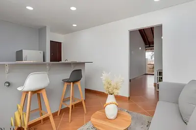 a living room with a couch and two stools at Aria Living 500 - Modern with Private Terrace in Guayaquil