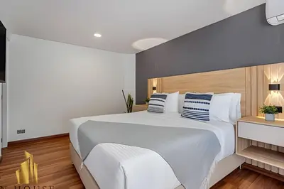 a bedroom with a large bed with white sheets and pillows at Aria Living 502 - Luxury Terrace in Laureles in Guayaquil